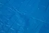 A close-up, textured view of a blue tarp. Produktbild-Vorschau