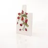 A white ceramic cutting board with a strawberry pattern, displayed on a white reflective surface. Produktbild-Vorschau