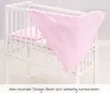 A pink duvet cover is draped over a white crib. Produktbild-Vorschau