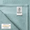 A close-up of a light blue towel, showing the label and a certification mark. Produktbild-Vorschau