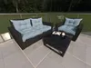 Outdoor patio furniture set on a tiled balcony with a grassy area and trees in the background. Produktbild-Vorschau