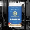 A product shot of a protein powder container in a gym setting. Produktbild-Vorschau