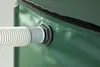 A close-up view of a green water tank with a hose attached to a spigot. Produktbild-Vorschau