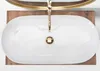 A top-down view of a white oval countertop sink with a gold faucet. Náhled obrázku produktu