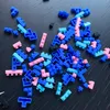 A pile of colorful building blocks scattered on a dark surface. Produktbild-Vorschau