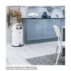 A modern kitchen scene featuring a white pedal bin, cabinets, and a chair. Náhled obrázku produktu