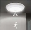 A motion-activated LED ceiling light is shown mounted on a ceiling, with a graphic representation of motion detection and a running person icon projected onto a wall below. Produktbild-Vorschau