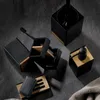 A collection of black and wood bathroom accessories arranged on a dark gray surface. Náhled obrázku produktu