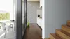 Interior view of a modern home with a kitchen and a patio area visible through glass doors. Produktbild-Vorschau