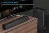 A soundbar and subwoofer are placed on a wooden cabinet in front of a television screen. Podgląd zdjęcia produktu