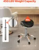 A saddle stool with a gas lift is shown on a floor, with close-ups of the gas lift and weight capacity information. Podgląd zdjęcia produktu