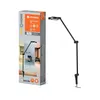 The image shows the product packaging and the product itself, a black desk lamp with a clamp base. Produktbild-Vorschau