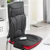 A black and red shiatsu massage seat mat is placed on a chair in a room with a white bookshelf and a floor lamp. Náhľad obrázku produktu