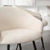 A close-up view of the textured upholstery of a cream-colored chair, with another chair visible in the background. Produktbild-Vorschau