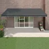 An awning is installed over a sliding glass door on a brick wall, with a patio and lawn in front. Anteprima dell’immagine prodotto