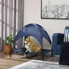 A corgi dog sits on a raised pet bed with a blue canopy in a living room setting. Produktbild-Vorschau