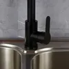 A close-up shot of a black kitchen faucet with a silver sink. Produktbild-Vorschau