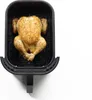 A whole roasted chicken is placed inside a black air fryer basket. Produktbild-Vorschau