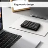 A desk setup with a laptop, a wireless numeric keypad, and a pen. Podgląd zdjęcia produktu