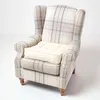 A wingback armchair with a cream and blue plaid fabric and a separate cream cushion on the seat. Produktbild-Vorschau