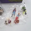 Several small plastic figures of people and accessories are displayed in clear plastic packaging, with a portion of a product box visible at the top. Náhľad obrázku produktu