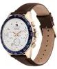 A close-up, angled shot of a Tommy Hilfiger watch with a white face, brown leather strap, and gold-toned case. Anteprima dell’immagine prodotto