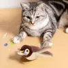 Braun-beiges Plüschvogel-Katzenspielzeug mit gelbem Schnabel und roten Augen, auf Holzboden, während eine Katze zusieht Náhľad obrázku produktu