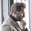 A man wearing a headset and coat, looking to the side. Produktbild-Vorschau