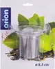 A tea strainer in its packaging, with green leaves and tea leaves as background. Náhľad obrázku produktu
