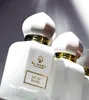 Two white perfume bottles with gold accents are displayed, with one bottle in the foreground and another slightly behind it. Produktbild-Vorschau