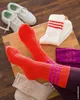 A collection of socks and shoes arranged on a wooden surface. Produktbild-Vorschau