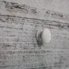 A close-up view of a white wooden drawer knob on a distressed white and gray wooden surface. Anteprima dell’immagine prodotto