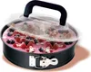 A close-up shot of a round springform cake pan filled with a pink dessert topped with various berries and a clear plastic lid with a black handle. Produktbild-Vorschau
