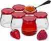 A group of empty glass jars with red lids, a spoon with jam, a strawberry, and a raspberry. Produktbild-Vorschau