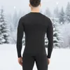 A person wearing a black long-sleeved shirt and pants stands in a snowy forest with trees in the background. Náhľad obrázku produktu