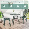 A green metal bistro set with two chairs and a table on a wooden deck, with a white wooden wall in the background. Náhľad obrázku produktu