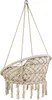 A beige macrame hanging chair with cushions and fringe, suspended by ropes. Voir les images du produit