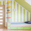 A child's bedroom with a bed, shelves, and a clock on a striped wall. Produktbild-Vorschau