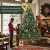 A father and son are decorating a Christmas tree in a cozy living room with a fireplace. Produktbild-Vorschau