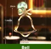 A close-up of a decorative LED bell light, likely for Christmas, hanging in a dimly lit room with bokeh lights in the background. Dimensions are indicated by text overlays. Produktbild-Vorschau