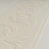 A close-up of a textured wallpaper border with an embossed floral pattern. Náhľad obrázku produktu