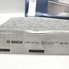 A close-up of a Bosch cabin air filter and its packaging. Produktbild-Vorschau