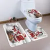 A toilet with a Christmas-themed toilet seat cover and bath mats. Produktbild-Vorschau