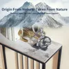 A console table with decorative items and books, set against a backdrop of snowy mountains. Podgląd zdjęcia produktu