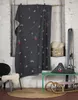 A cozy winter scene with a ski-themed blanket draped over a wall, skis, a sled, and a chair with a sheepskin. Produktbild-Vorschau