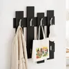 A coat rack mounted on a white wall, displaying a coat, a tote bag, and a baseball cap. Produktbild-Vorschau