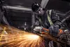 A worker in a workshop is using an angle grinder, creating a shower of sparks. Voir les images du produit
