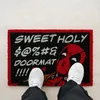 A person's feet wearing white sneakers stand on a doormat with a Deadpool graphic and text. Produktbild-Vorschau