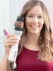 A woman is holding a hair dryer and styling her hair. Náhled obrázku produktu