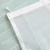 A close-up view of a white sheer curtain with text printed on it, layered over a light green background with more text. Produktbild-Vorschau